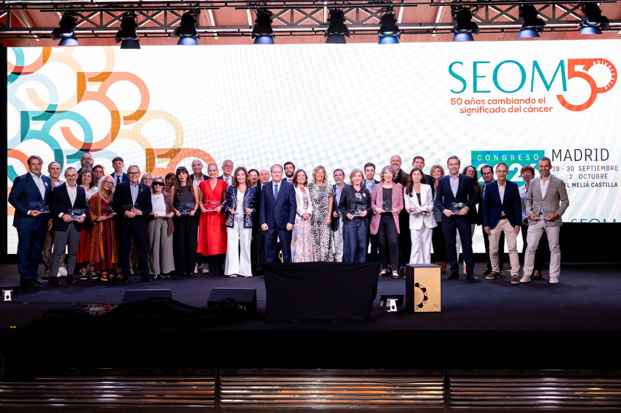 Foto de familia de los reconocidos en la gala del 50 aniversario de SEOM, en el escenario del congreso de Madrid